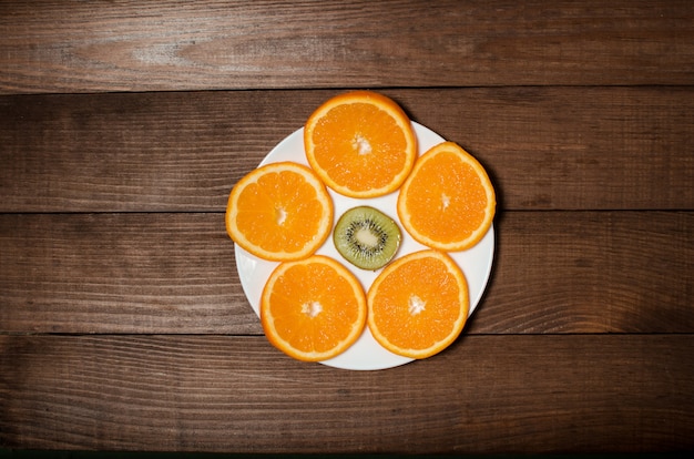 Foto los cítricos se encuentran en un plato blanco sobre un fondo de madera.