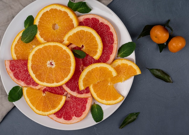 Los cítricos maduros se redujeron a la mitad en un plato blanco, de alta resolución. Fondo de naranjas y pomelos