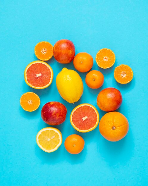 Cítricos naranjas mandarinas limones naranjas sanguinas sobre un fondo azul