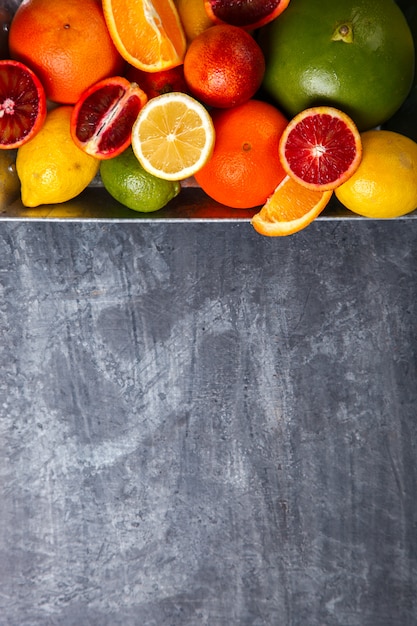 Foto citrinos diferentes em uma bandeja do metal em gray background.