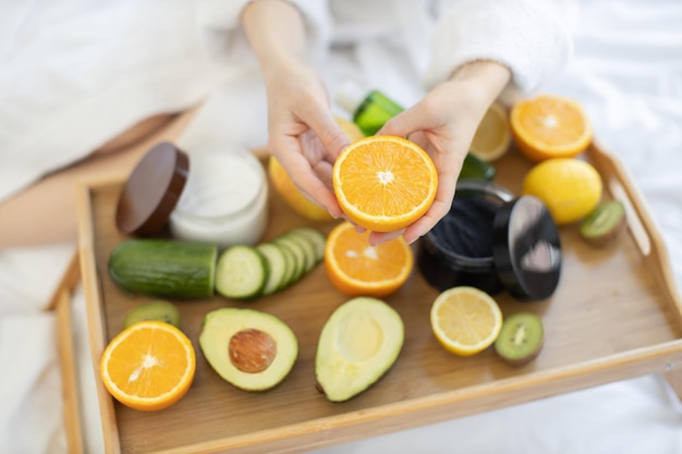 Citrus nas mãos acima de remédios naturais de beleza na bandeja da cama