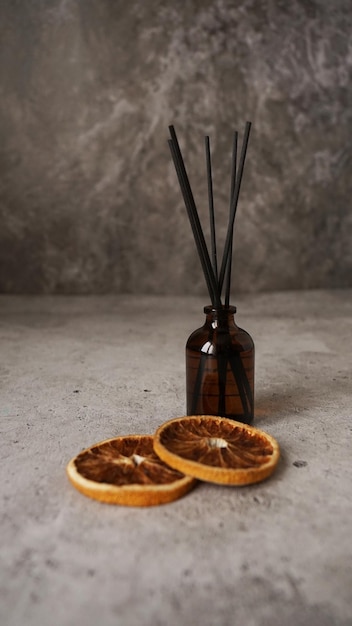 Citrus Reed Diffusor auf dunklem Hintergrund Flaschensticks und trockene Orangen