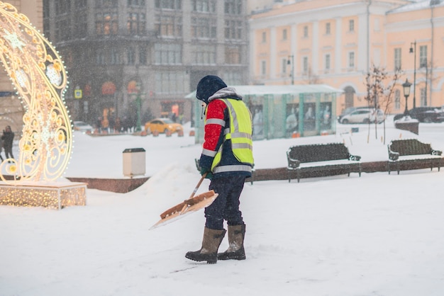 City-Service-Typ reinigt Schnee von Straßen mit Schaufel b