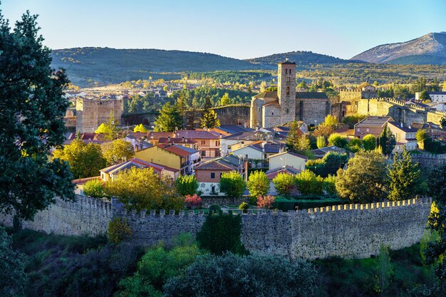 Ciudad amurallada con edificios medievales al atardecer en tonos dorados. Buitrago de Lozoya, Madrid.