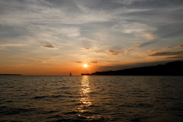 ciudad balneario en la costa eslovena. cielo naranja del atardecer en verano. Vista panorámica al muelle de madera. Mar