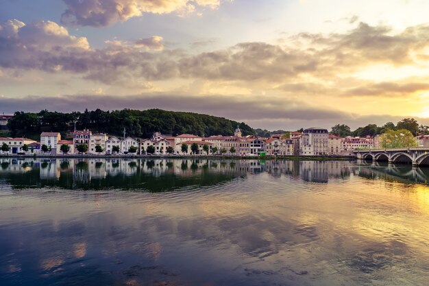 Ciudad de Bayona en Francia por la noche con casas de arquitectura típica y reflexiones sobre el río Adur. Europa.