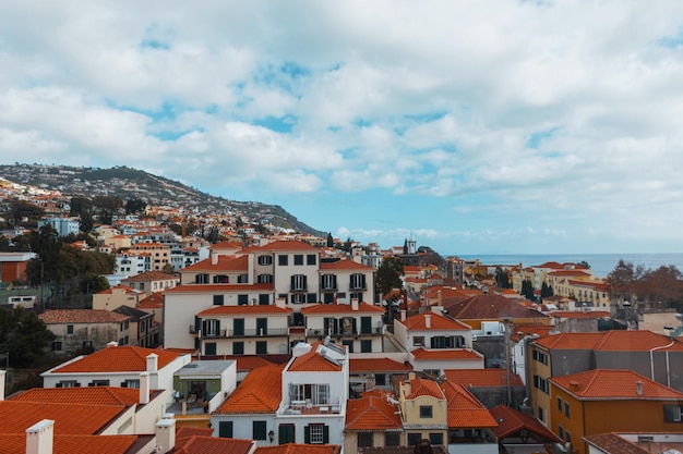 Ciudad de Funchal con casas y techos naranjas vista desde un teleférico Isla de Madeira