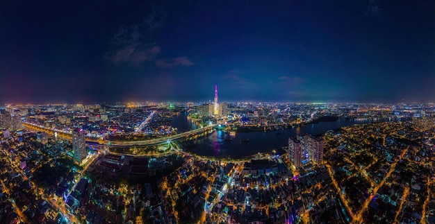 Ciudad Ho Chi Minh Vietnam DEC 10 2022 Vista aérea de la puesta de sol en Landmark 81 es un rascacielos súper alto y un puente de Saigón con edificios de desarrollo a lo largo del paisaje urbano del río Saigón en la noche