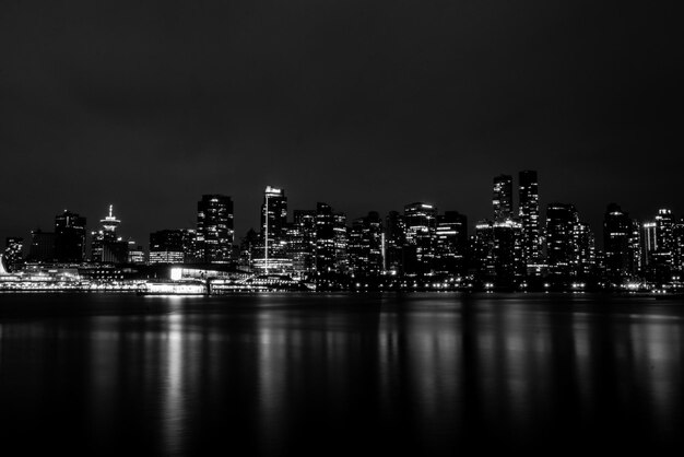 Ciudad iluminada por el río contra el cielo nocturno