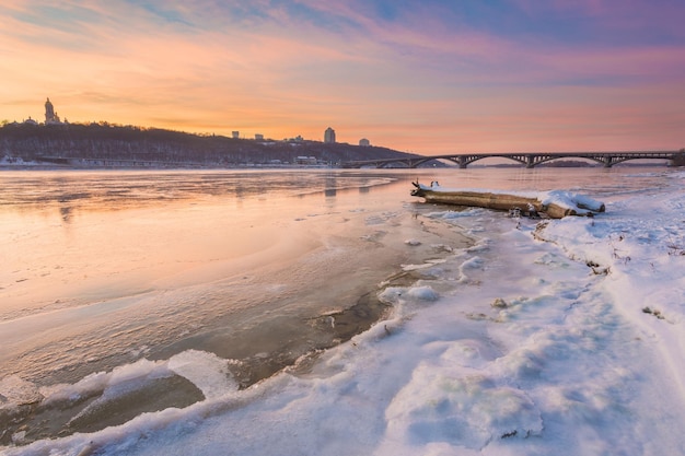 Ciudad de invierno de Kiev en la noche en el río