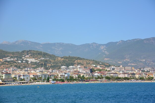 ciudad mediterránea alanya con fondo de montaña y cielo azul, vista desde el mar hasta la costa