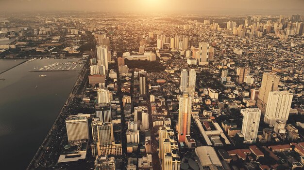 Foto ciudad metrópolis en la bahía del mar amanecer aérea filipinas paisaje urbano al amanecer calles urbanas carreteras