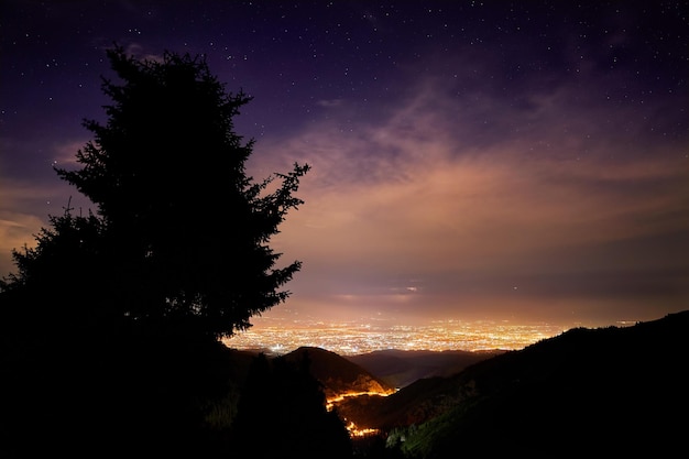 Ciudad de noche y cielo estrellado.