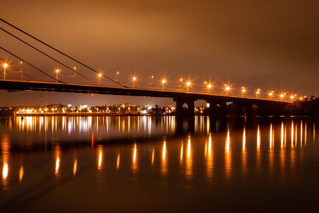 Ciudad nocturna con reflejo de casas en el río.