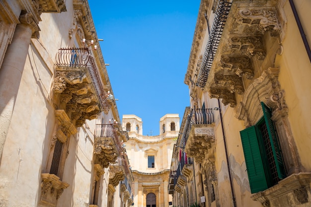 Foto ciudad de noto en sicilia, la maravilla barroca - patrimonio de la unesco. detalle del balcón del palazzo nicolaci, máxima expresión del estilo barroco siciliano.