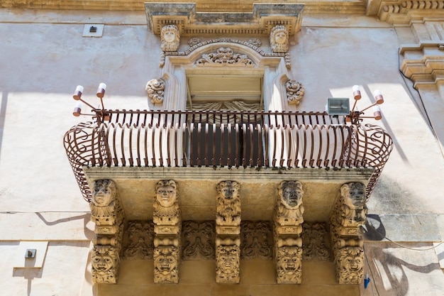 Foto ciudad de noto en sicilia, la maravilla barroca - patrimonio de la unesco. detalle del balcón del palazzo nicolaci, máxima expresión del estilo barroco siciliano.