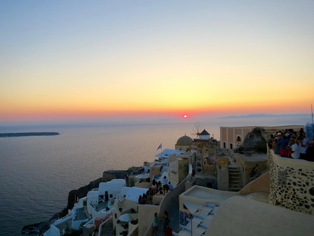 Foto ciudad en santorini junto al mar egeo contra el cielo durante la puesta de sol