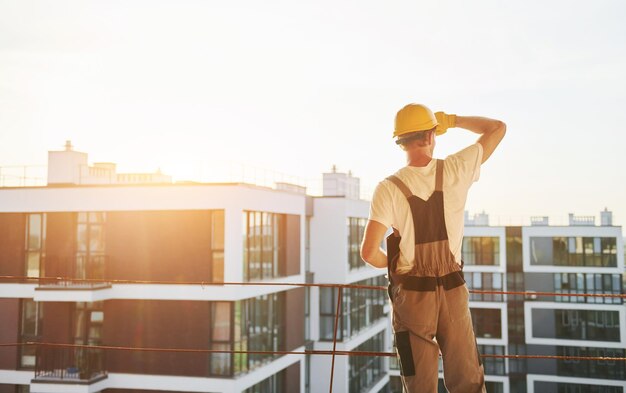 Ciudad de los sueños Joven trabajando en uniforme en la construcción durante el día