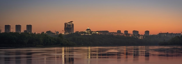 Foto ciudad de la tarde junto al panorama del río amanecer o atardecer naranja sobre la ciudad