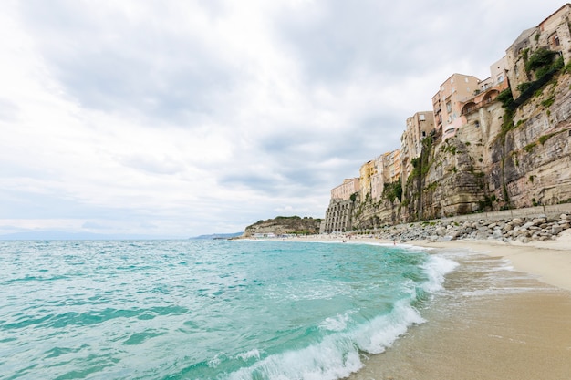 Foto la ciudad de tropea y la playa de la costa del mar tirreno con coloridos edificios de agua turquesa