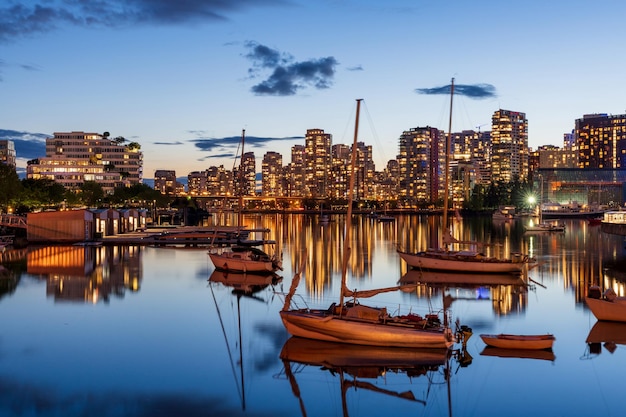 Ciudad urbana noche horizonte crepuscular de vancouver barcos en el reflejo de las luces de los edificios de false creek