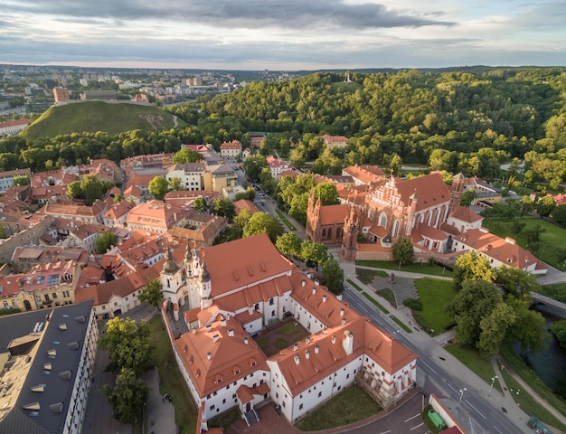 Foto ciudad vieja de vilna con la iglesia de santa ana y el castillo de gediminas en el fondo museo del patrimonio de la iglesia