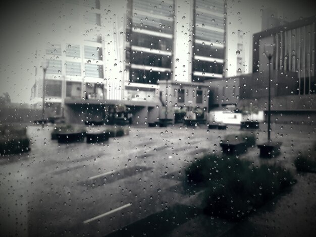 La ciudad vista a través de una ventana húmeda durante la temporada de lluvias