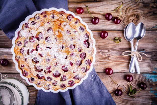 Clafoutis-Kirschkuchen auf rustikalem Holzhintergrund