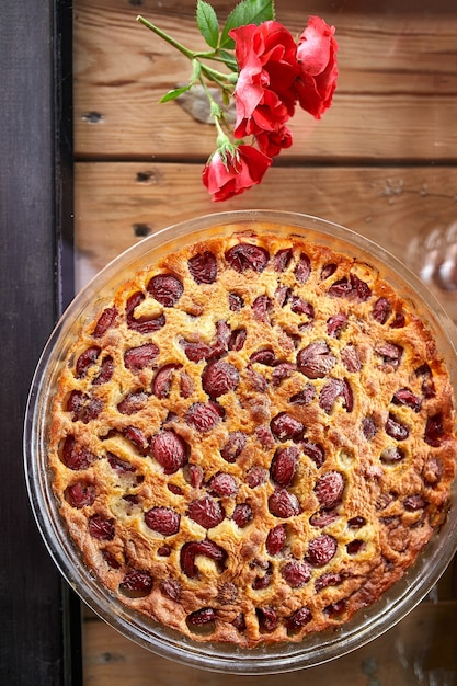 Clafoutis mit Kirsche auf einem hölzernen Hintergrund, traditionelles französisches süßes Fruchtdessert.