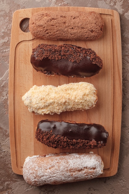 Éclairs franceses. Éclairs de chocolate e creme para o café. Doces para uma pausa para o café