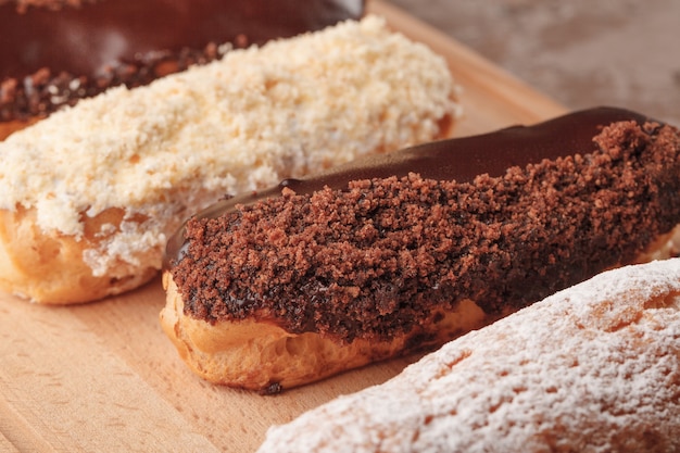 Éclairs franceses. Éclairs de chocolate e creme para o café. Doces para uma pausa para o café