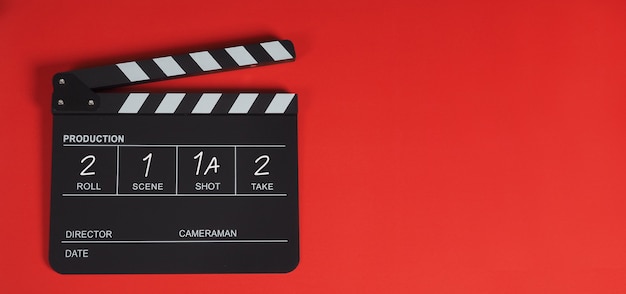 Clap board ou movie slate. É usado na indústria de vídeo e cinema em fundo vermelho.