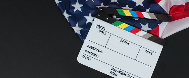 Clapper Board oder Filmschiefer und Flagge der Vereinigten Staaten von Amerika (USA.) auf schwarzem Hintergrund.