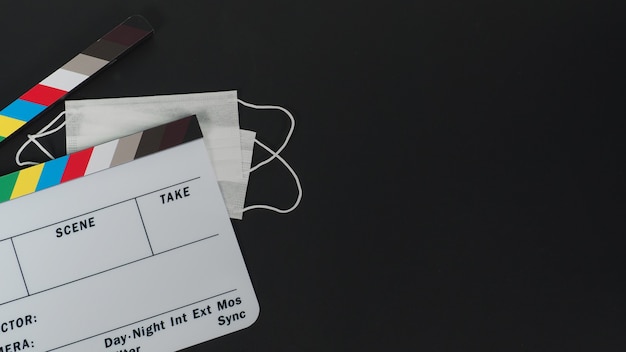 Clapper Board oder Filmschiefer und Gesichtsmaske, Megaphon auf schwarzem Hintergrund. Es wird in der Videoproduktion und Filmindustrie verwendet.