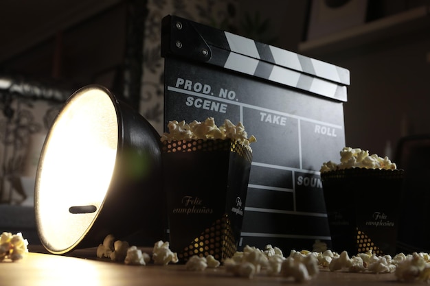 Clapper de película con una caja de palomitas de maíz.