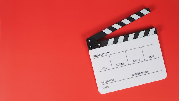 Foto clapperboard o pizarra de película que se utiliza en la producción de video en la industria del cine en fondo rojo