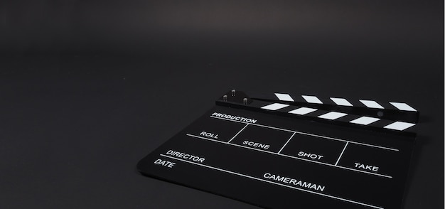 Clapperboard ou clap board ou movie slate uso na produção de vídeo, cinema, indústria do cinema em fundo preto.