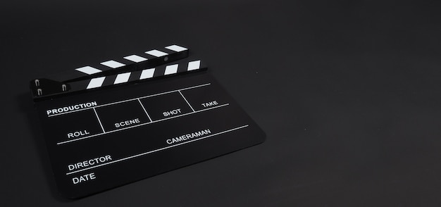 Clapperboard ou clap board ou movie slate uso na produção de vídeo, cinema, indústria do cinema em fundo preto.