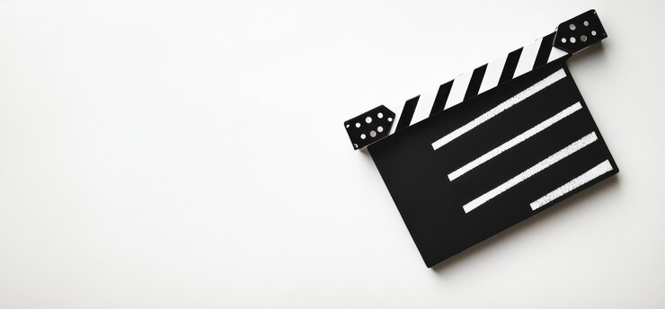 Un clapperboard de película en blanco y negro se sienta en un fondo blanco con espacio de copia