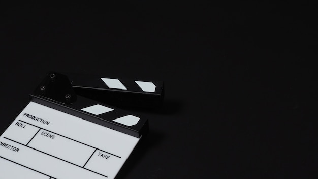 Claquete ou filme e cadeira. É usado na produção de vídeo, filme, cinema, indústria do cinema em fundo preto.