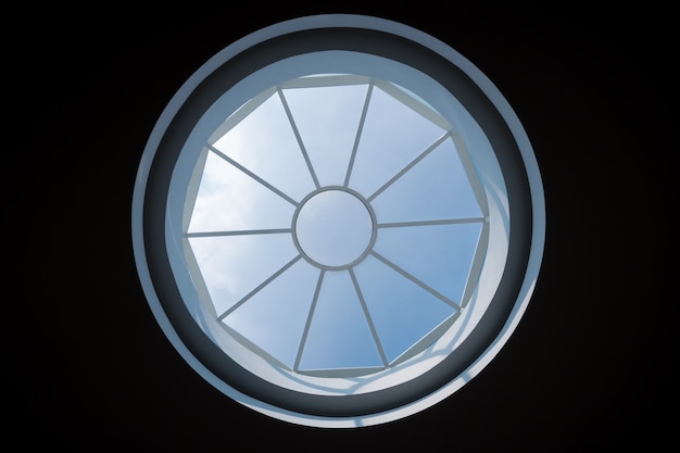 Clarabóia circular no teto com céu azul
