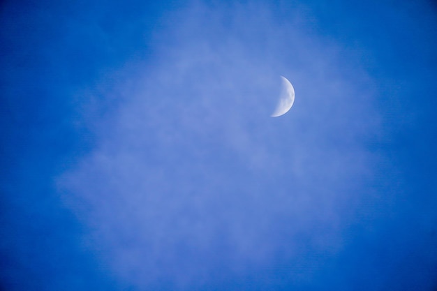 Claramente hermoso cielo azul con media luna blanca