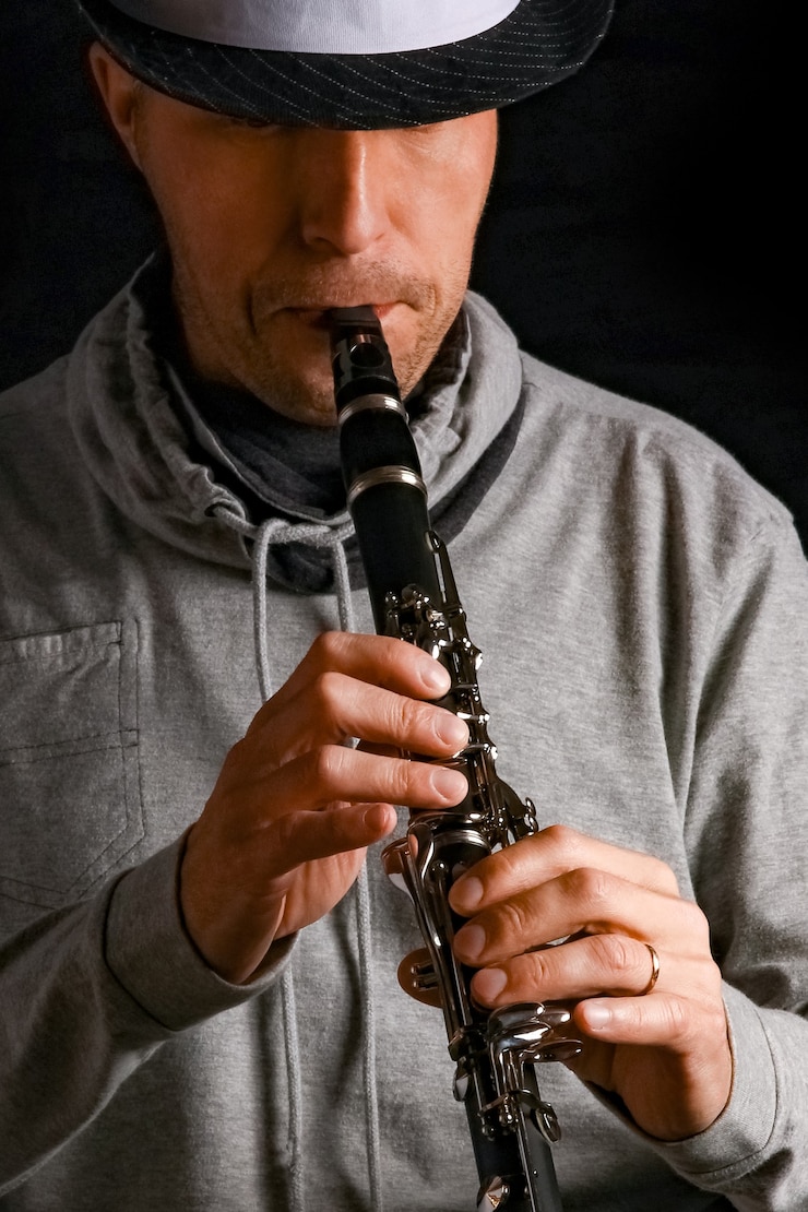 Foto clarinete en manos de un hombre sobre una superficie negra