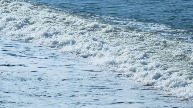 Claro día de verano sobre una costa de mar tranquila con grandes guijarros en cámara lenta