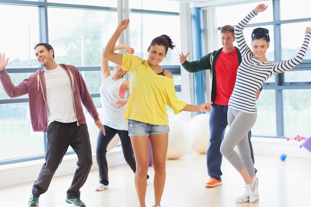 Clase de aptitud alegre e instructor haciendo ejercicio de pilates