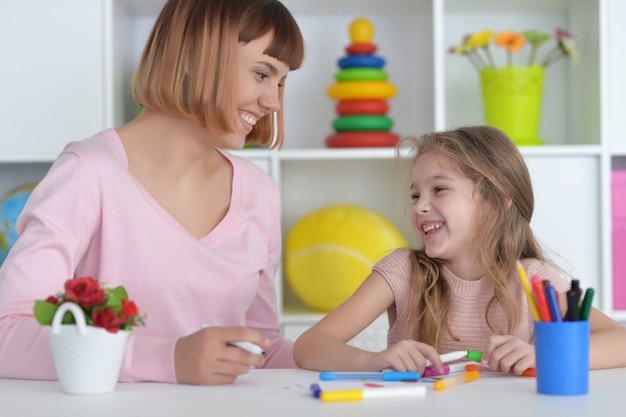 Clase de arte de la escuela primaria con hermosa maestra.