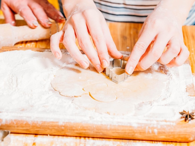 Clase de cocina de comida de panadería Primer plano de manos de mujer cortando masa haciendo galletas de jengibre