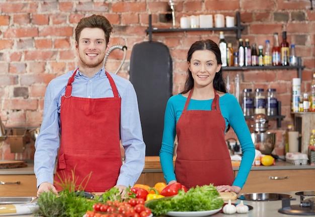 clase de cocina, concepto culinario, comida y personas - pareja feliz en la cocina