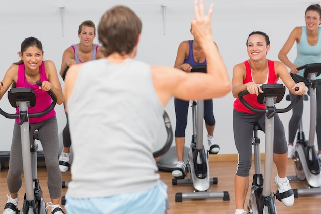 Foto clase de entrenador y gimnasio en la clase de spinning