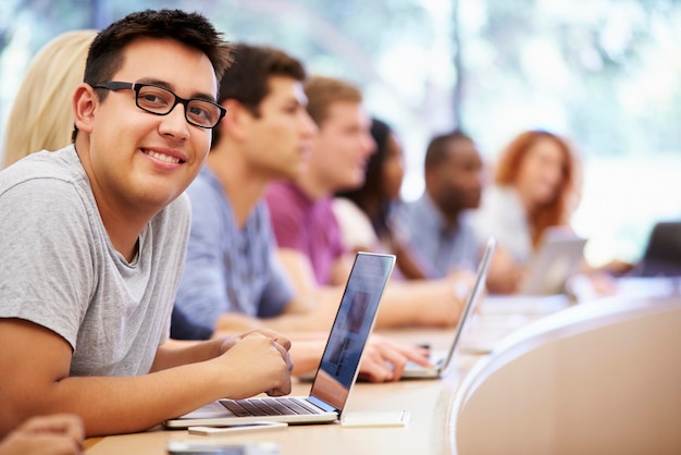 Clase de estudiantes universitarios que usan computadoras portátiles en la conferencia